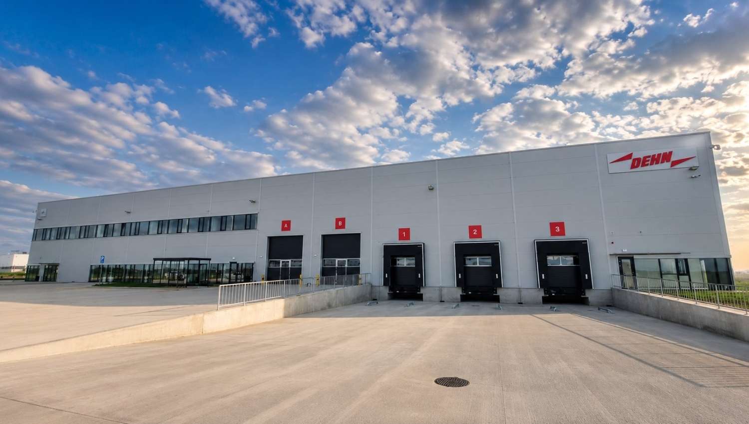 DEHN’s new manufacturing facility in Piteşti, Romania, with modern warehouse and production infrastructure under a partly cloudy sky.