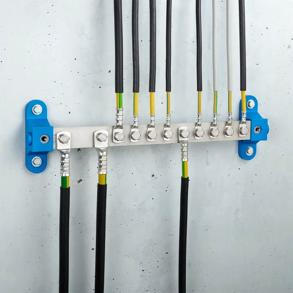 Metal grounding bar mounted on a wall with multiple black and green-yellow cables secured by bolts and two blue mounting brackets.