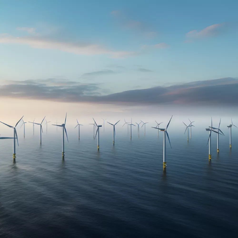 Group of offshore wind turbines standing in calm sea under a partly cloudy sky.