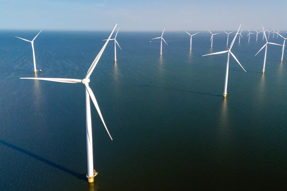 Offshore wind turbines standing in the sea under clear sky